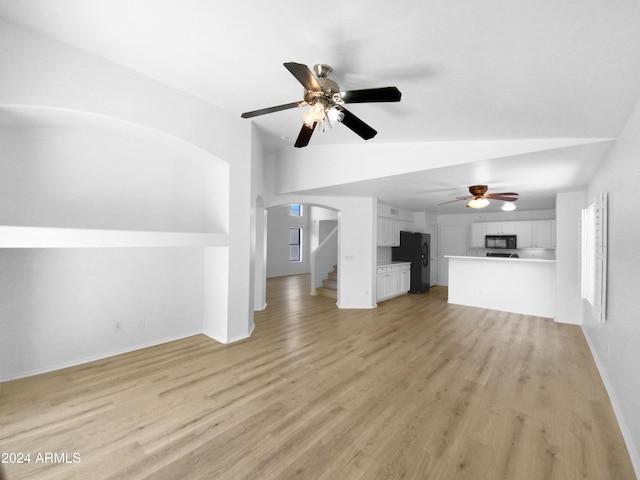 unfurnished living room featuring ceiling fan, vaulted ceiling, and light hardwood / wood-style flooring