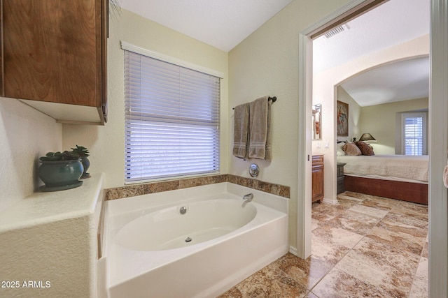11047 W Irma Ln, Peoria, AZ 85373 - ensuite bathroom featuring a bath, visible vents, baseboards, lofted ceiling, and ensuite bath