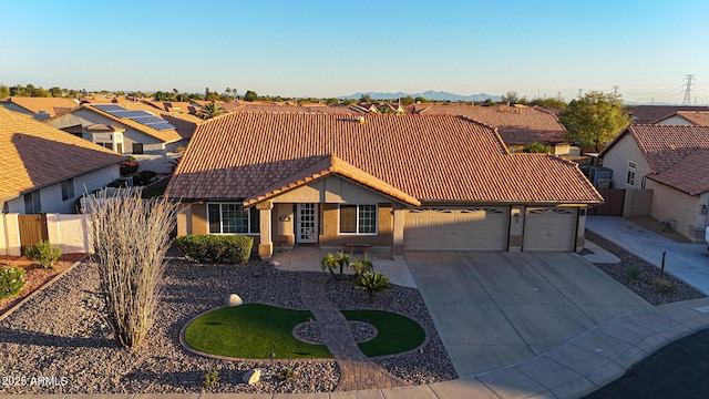 11047 W Irma Ln, Peoria, AZ 85373 - view of front of house with fence, driveway, an attached garage, and a tiled roof