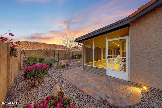 11047 W Irma Ln, Peoria, AZ 85373 - patio terrace at dusk featuring a fenced backyard and a sunroom