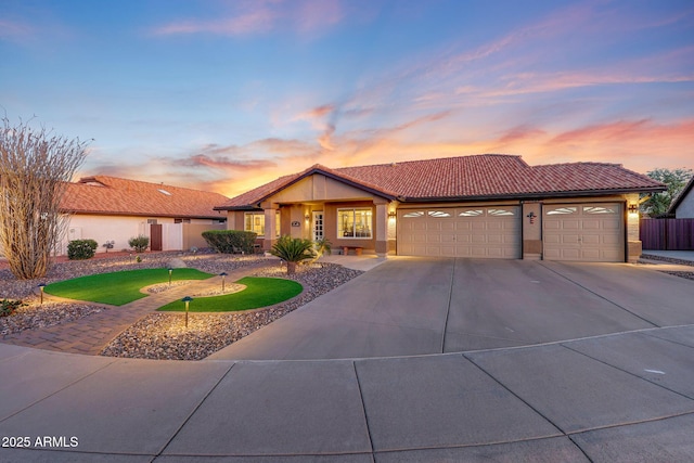 11047 W Irma Ln, Peoria, AZ 85373 - view of front of home featuring concrete driveway, stucco siding, fence, a tiled roof, and a garage