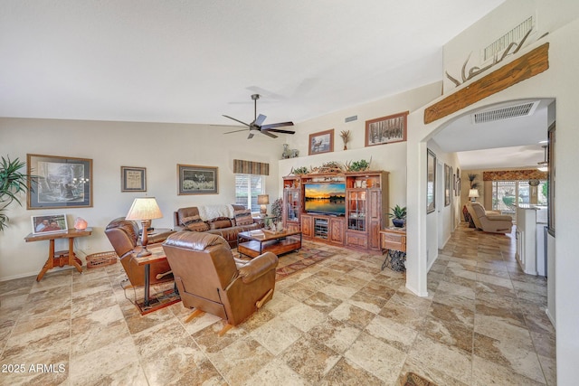 11047 W Irma Ln, Peoria, AZ 85373 - living area featuring vaulted ceiling, arched walkways, visible vents, stone finish flooring, and ceiling fan