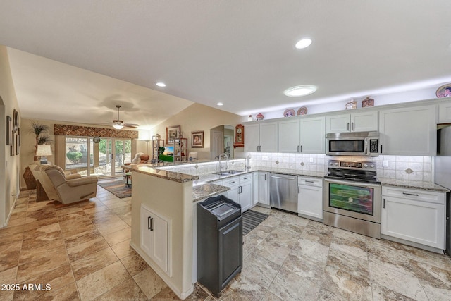 11047 W Irma Ln, Peoria, AZ 85373 - kitchen with a sink, a peninsula, open floor plan, stainless steel appliances, and arched walkways