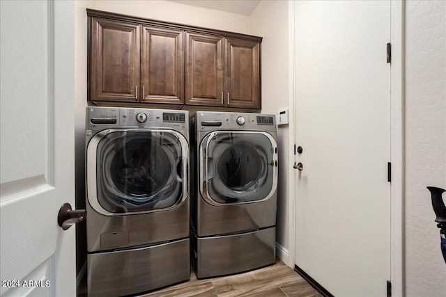 washroom featuring cabinet space, independent washer and dryer, and light wood finished floors