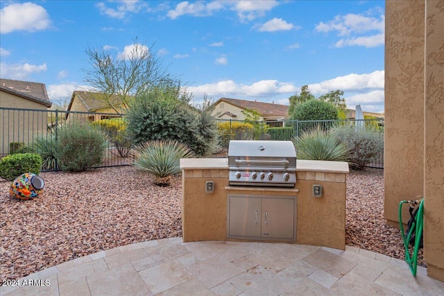 view of patio featuring grilling area, an outdoor kitchen, and a fenced backyard