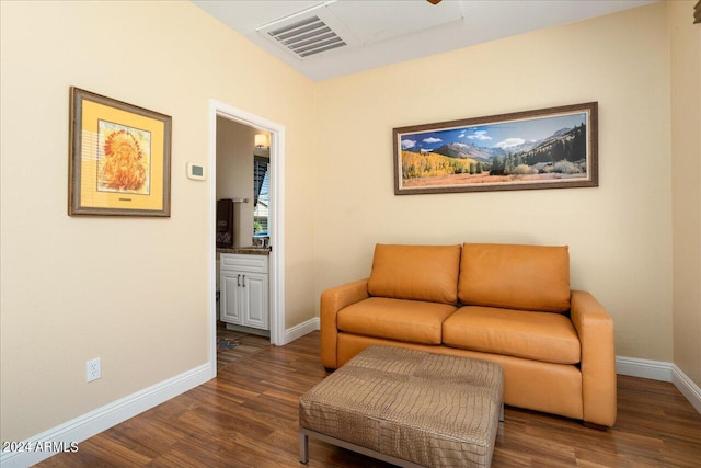 sitting room featuring dark wood-type flooring, visible vents, and baseboards