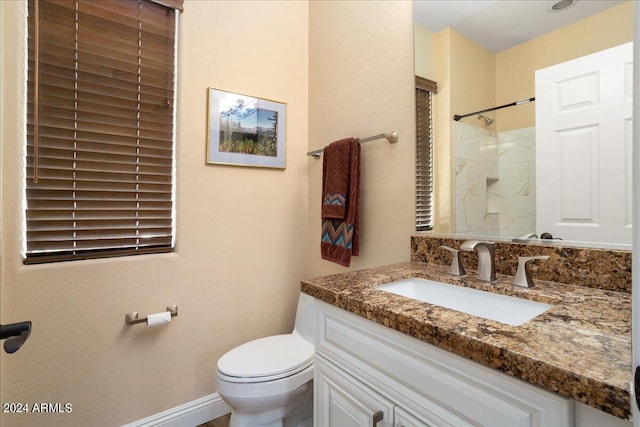 bathroom featuring toilet, walk in shower, and vanity