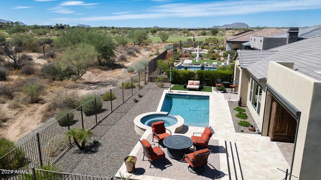 view of swimming pool with a fire pit, a patio, and an in ground hot tub