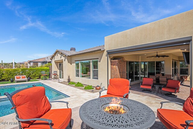 view of patio featuring ceiling fan and a fire pit