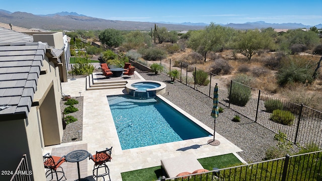 view of pool with an in ground hot tub, a mountain view, and a patio area