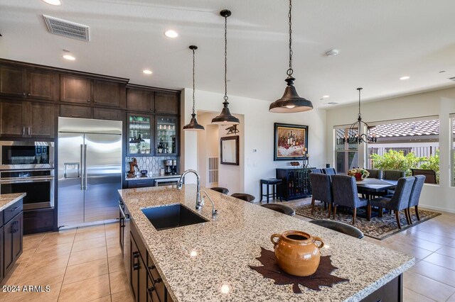 tiled living room with ceiling fan and sink