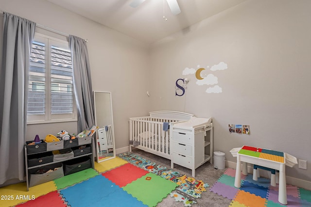 bedroom with ceiling fan and a nursery area