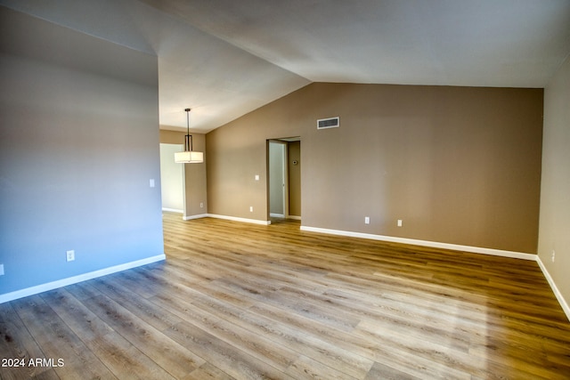 empty room with lofted ceiling and light hardwood / wood-style floors