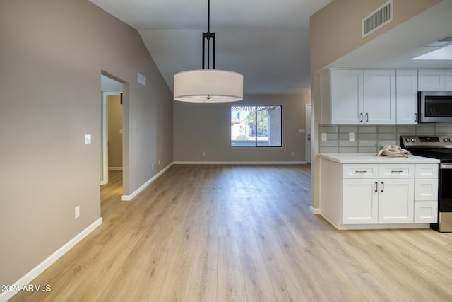 kitchen featuring appliances with stainless steel finishes, decorative light fixtures, backsplash, lofted ceiling, and white cabinets