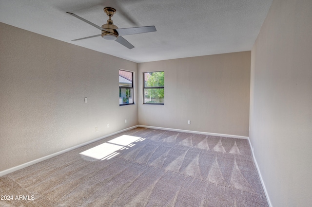 empty room with a textured ceiling, carpet floors, and ceiling fan