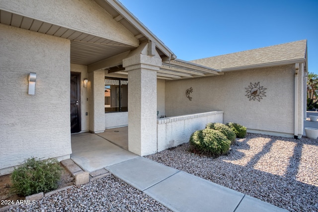 view of exterior entry with a patio