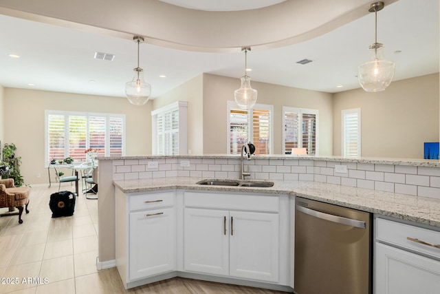 kitchen featuring stainless steel dishwasher, white cabinets, a sink, and light stone counters