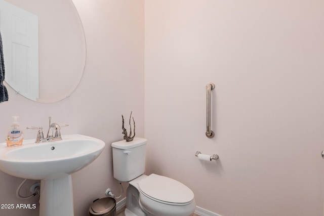 bathroom featuring toilet and baseboards