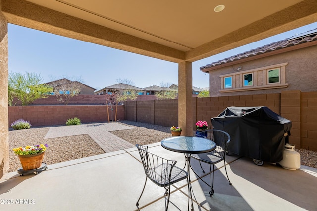 view of patio featuring a grill, a fenced backyard, and outdoor dining area