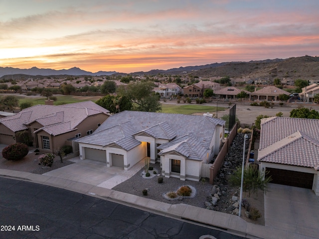 aerial view at dusk featuring a mountain view