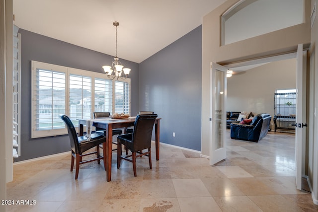 dining space featuring light tile patterned flooring, lofted ceiling, and a chandelier