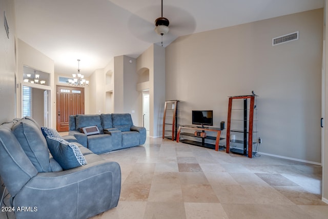 living room with a high ceiling and ceiling fan with notable chandelier