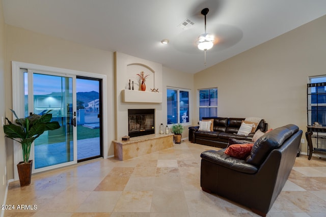 living room with ceiling fan, lofted ceiling, and a premium fireplace