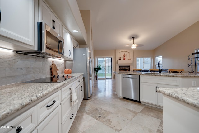 kitchen featuring light stone counters, sink, white cabinets, and appliances with stainless steel finishes