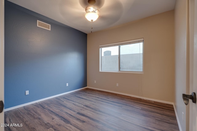 empty room with ceiling fan and dark hardwood / wood-style flooring