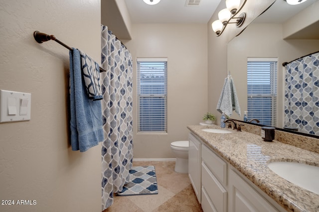 bathroom with tile patterned flooring, vanity, toilet, and plenty of natural light