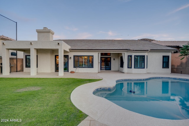 view of pool featuring a lawn and a patio