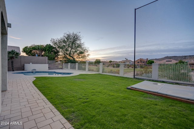 yard at dusk with a fenced in pool and a patio area