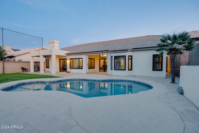 pool at dusk with a patio