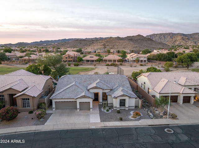 aerial view at dusk featuring a mountain view