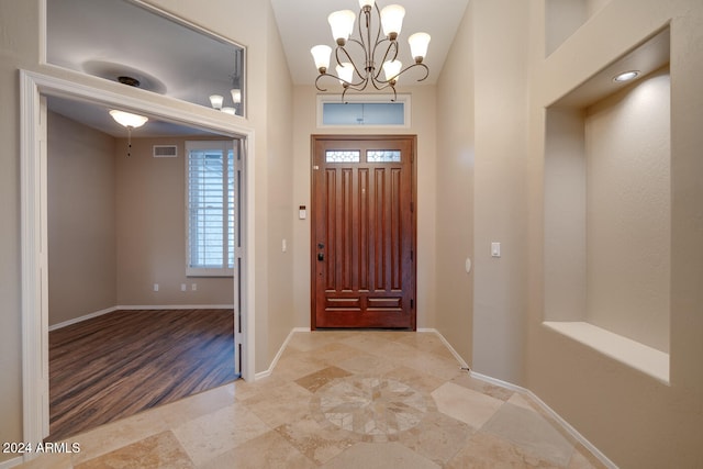 entrance foyer featuring light wood-type flooring and a notable chandelier