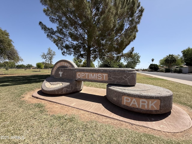 community sign featuring a yard