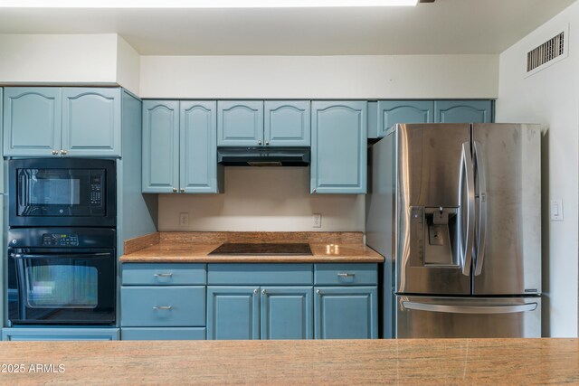 kitchen with black appliances, under cabinet range hood, blue cabinetry, and light countertops