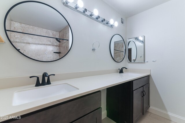 full bath featuring double vanity, baseboards, and tile patterned flooring