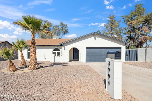 ranch-style home with a garage, concrete driveway, and fence