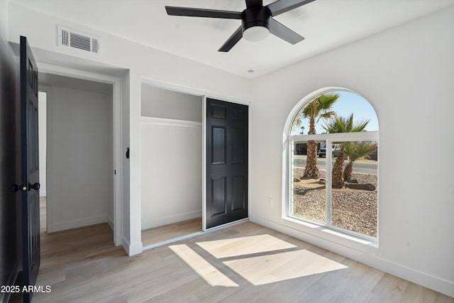 unfurnished bedroom with a closet, visible vents, light wood-style flooring, and baseboards