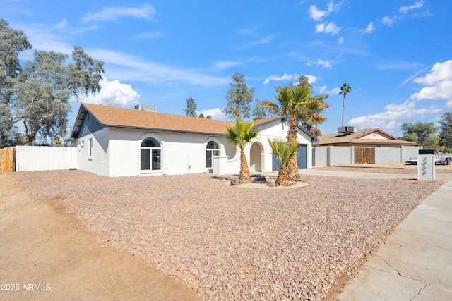 single story home featuring driveway, an attached garage, and fence