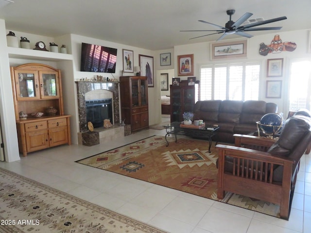 living room with a ceiling fan, tile patterned floors, plenty of natural light, and a fireplace