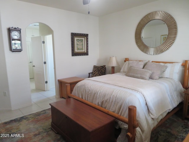 tiled bedroom with arched walkways and baseboards