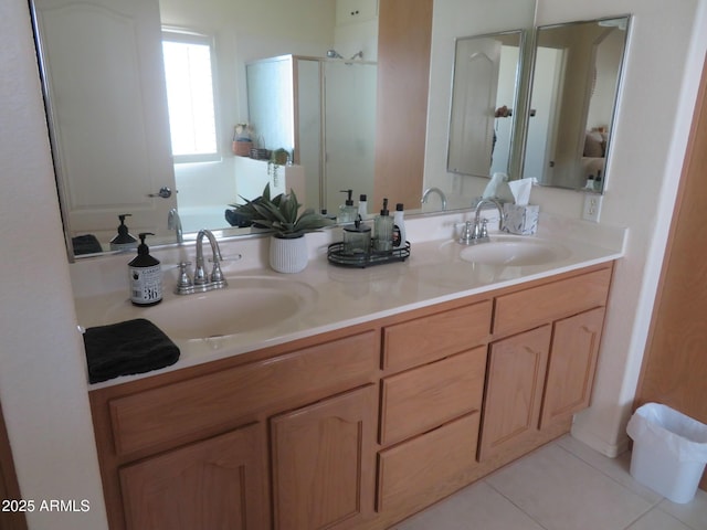 full bathroom featuring double vanity, a shower stall, a sink, and tile patterned flooring