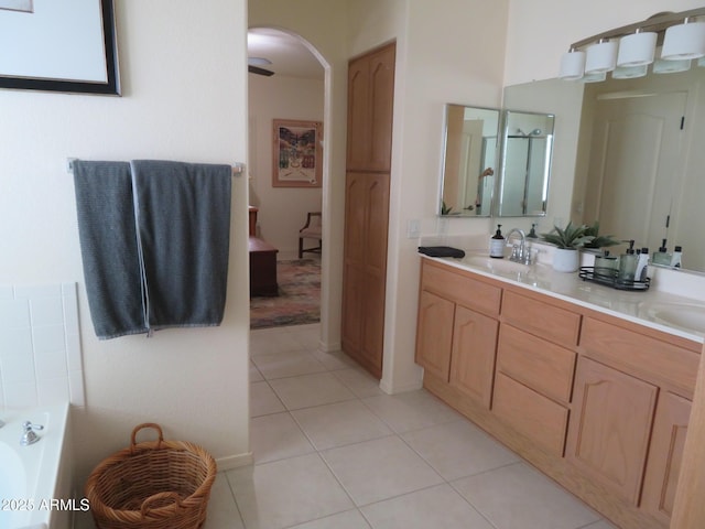 full bathroom with a garden tub, a sink, tile patterned floors, and double vanity