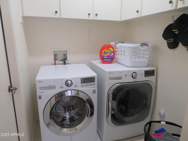 washroom featuring cabinet space and washing machine and clothes dryer