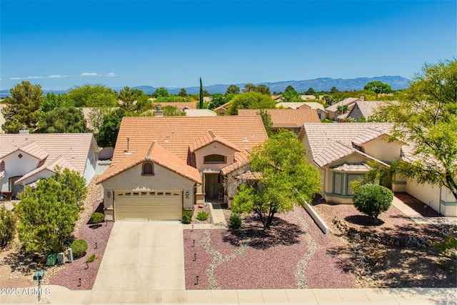 ranch-style house with concrete driveway, an attached garage, a tile roof, and stucco siding