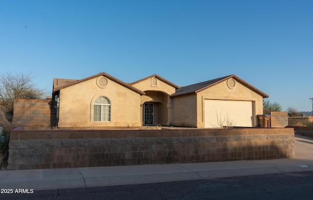 view of front of home with an attached garage, fence, concrete driveway, and stucco siding