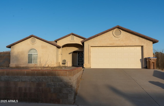 view of front of home featuring a garage, driveway, and stucco siding