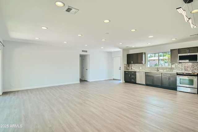 1930 E Missouri Ave, Phoenix, AZ 85016 - kitchen with appliances with stainless steel finishes, recessed lighting, tasteful backsplash, light countertops, and light wood-style flooring
